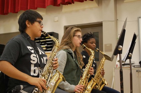 Melissa Navarro ‘17, Alaina Speiser ‘16, and Olatundun Awosanya ‘16 practice playing their saxophones in class. Saxophones are members of the woodwind family.
