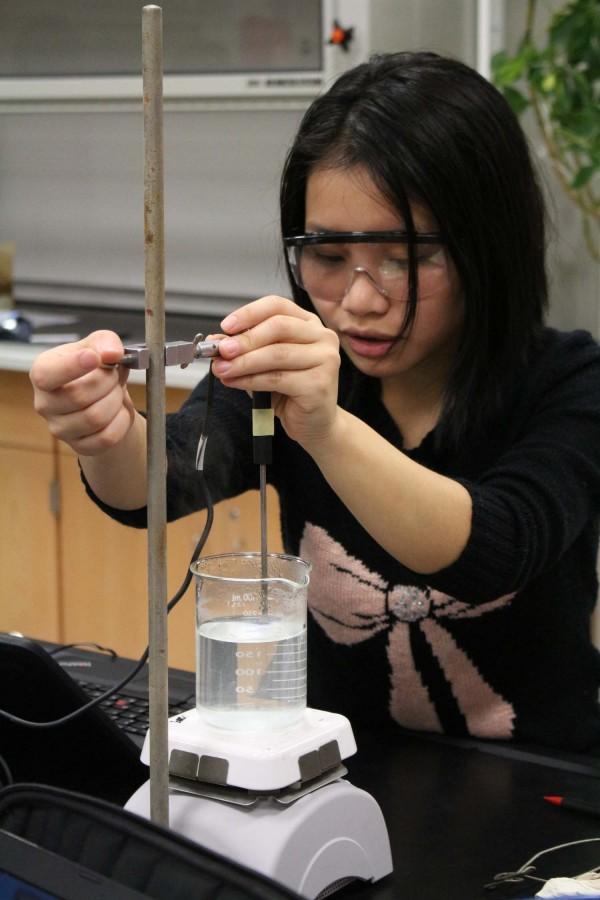 Senior Elly Mawi takes the temperature of a solution for a chemistry on Jan. 22. 