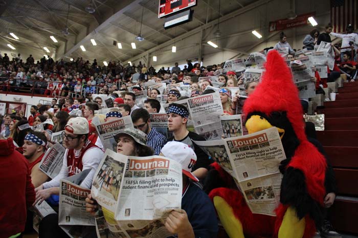 The students in the birdcage mock the other team by reading the school newspaper before the game against Evansville Reitz on Feb. 28.