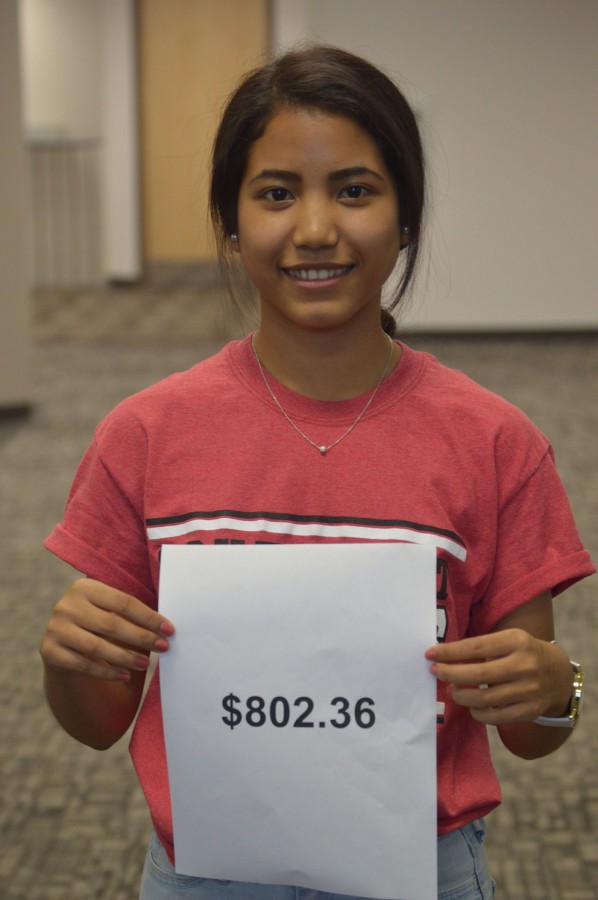 Junior Van Hnem stands with the holding a sheet with the amount of money raised from the fundraiser she played a major role in organizing along side English teacher Ms. Sara Kohne. Hnem says shes proud of the amount of money SHS was able to raise.