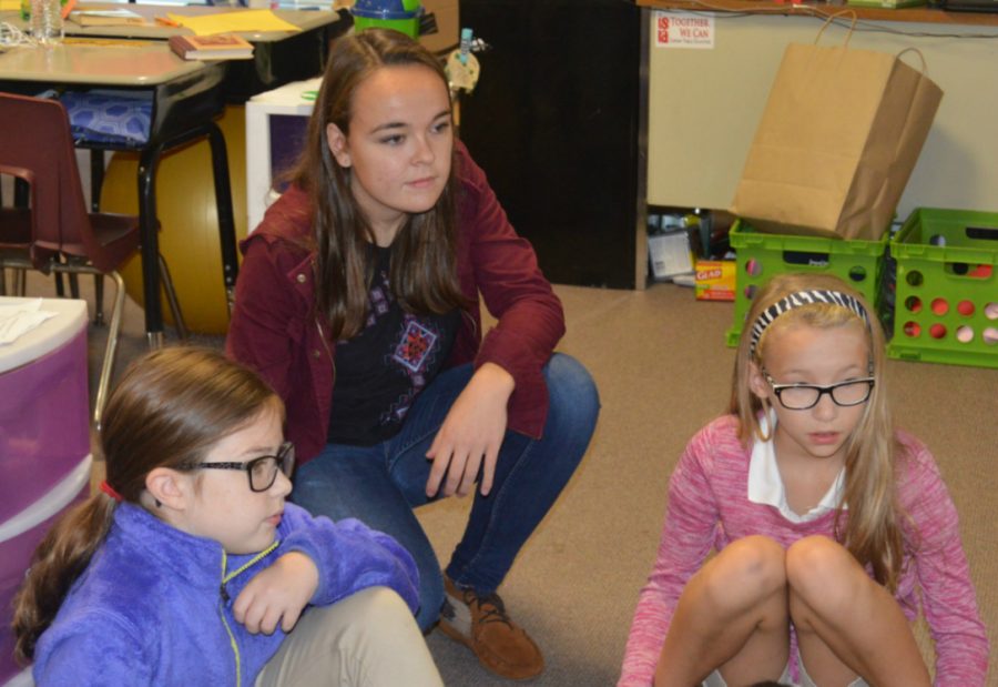 Senior Megan Sullivan helps Amanda Colbert’s fifth grade class with their reading on Sept. 28 at Mary Bryan. Sullivan helps the students attain and use cognitive skills as well as grade their papers. 