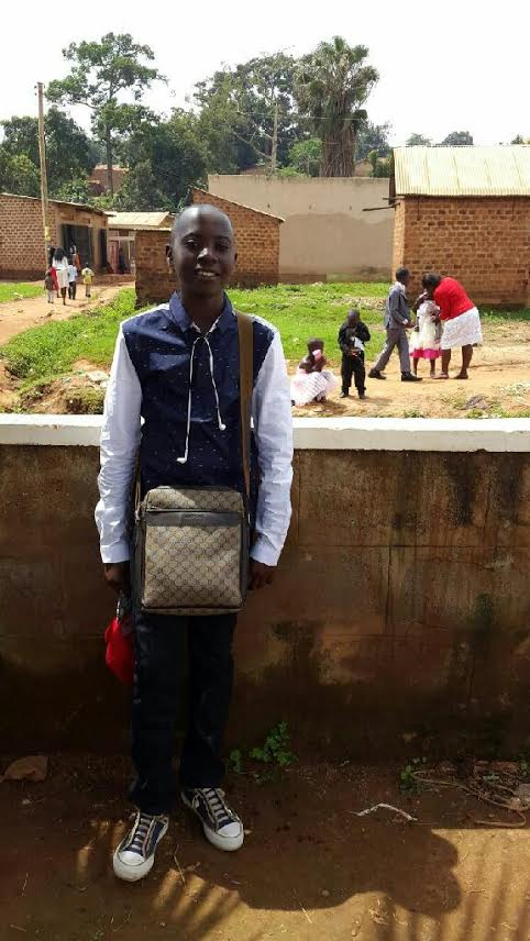 Freshman Samuel Kile poses outside of his church after a service in Uganda. Kile was 12 in the picture.