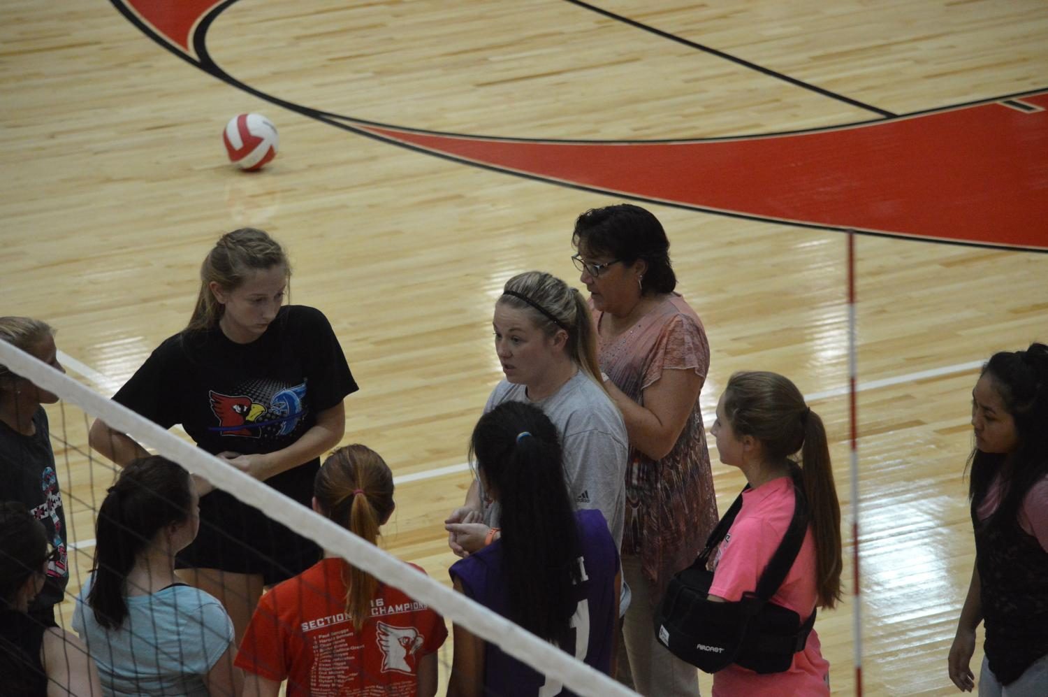 The freshman team huddles and listens to coach Katherine Busch during a practice.