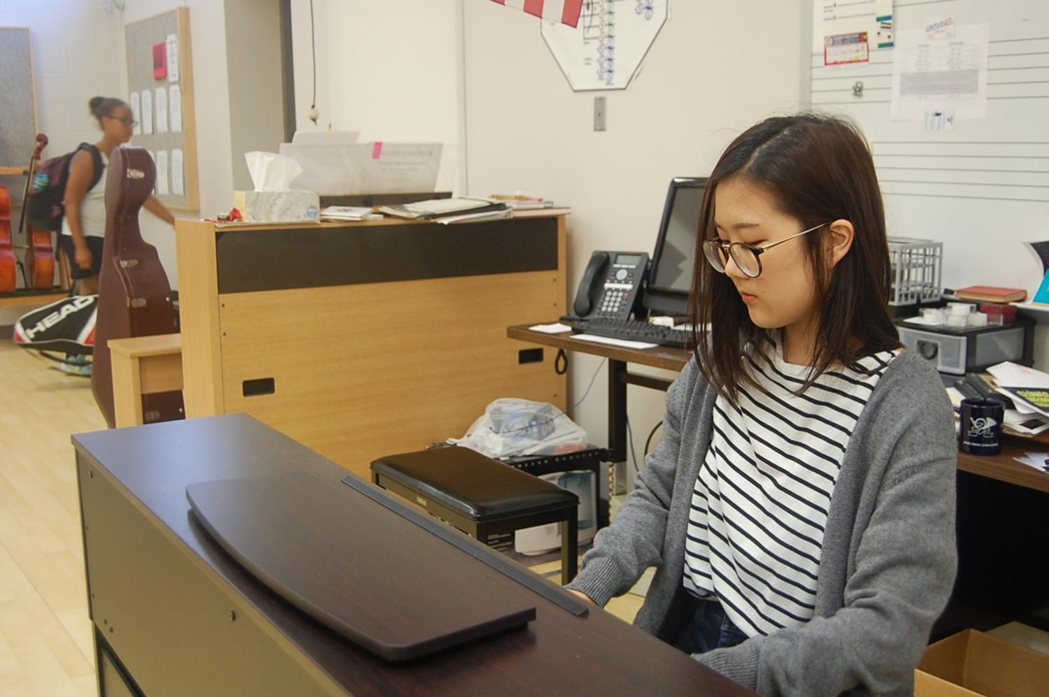 Senior Lydia Mun plays French Suite in G major by Bach in the orchestra room.