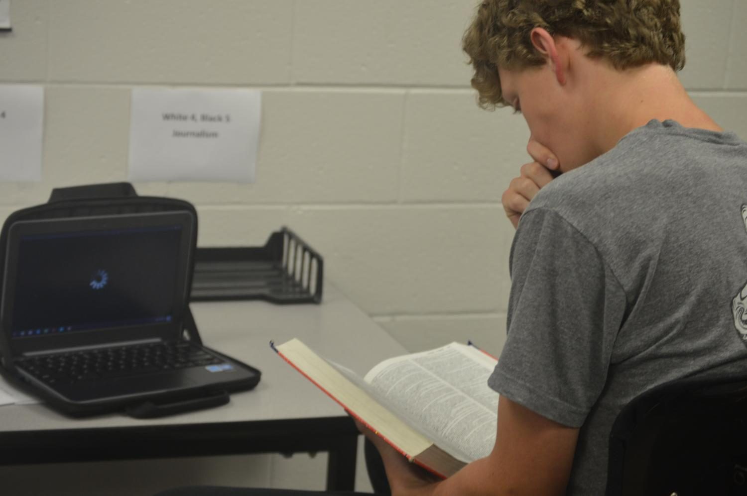 Senior Ethan Vanhalen II resorts to reading the dictionary as Bloons Tower Defense 5 struggles to load on his chromebook. This is by far the worst thing Ive ever Experienced, Vanhalen said. Now Im mad and know 15 different words to express my anger with. 