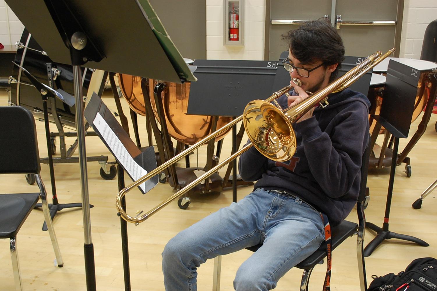 senior zephaniah mccool plays the trombone during his jazz band