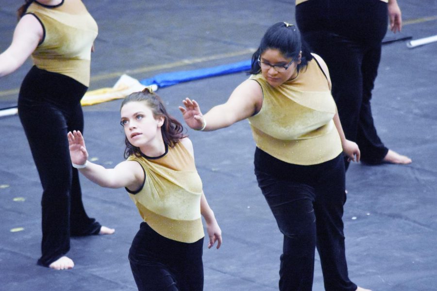 Sophomore Olivia Modglin and freshman Elizabeth Coyotl reach out their arms and dance in the beginning of their show, Human, at Columbus East High School on Feb. 3. The color guard got a sliver award with a 41.990 out of 50.