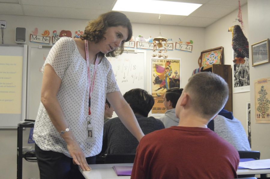 Foreign language teacher Jamie Marshall helps sophomore Blake Ward while wearing her photo identification. 