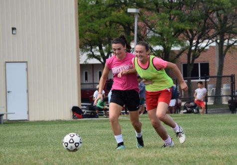 Sophomore Emma Main (left) and senior Jordan Cox (right) chase the ball at a practice on Aug. 9.