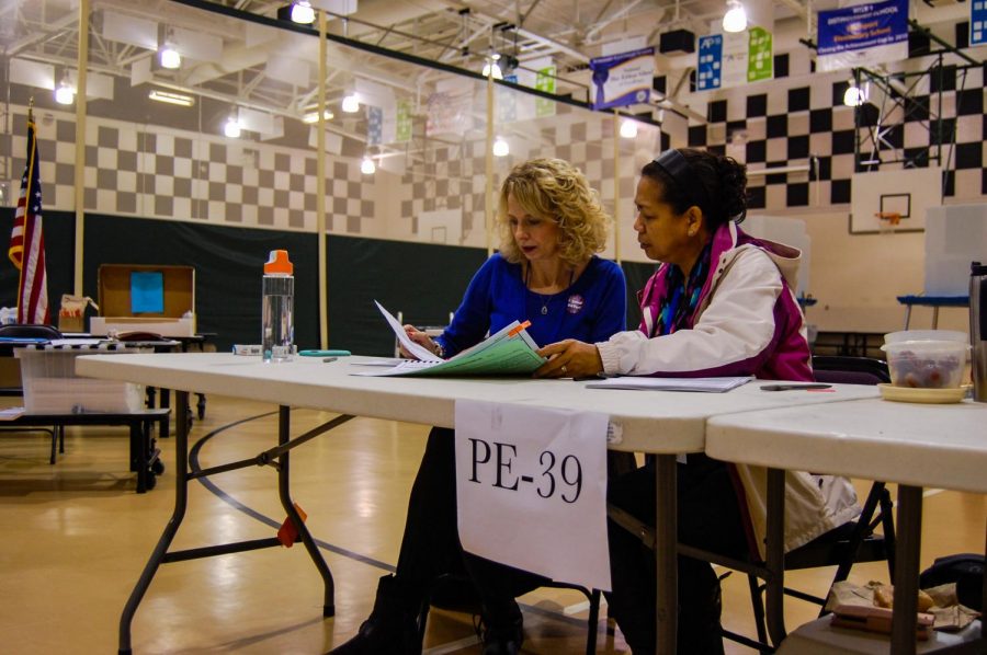 Poll workers from Precinct 39 go over paperwork and forms at the PTEC voting site on Nov. 6.