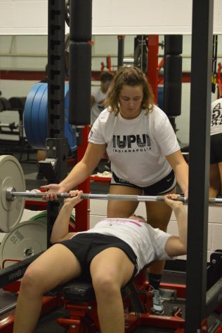 Senior Kenzie Lukas spots her lifting partner as they bench press on Nov. 6. 