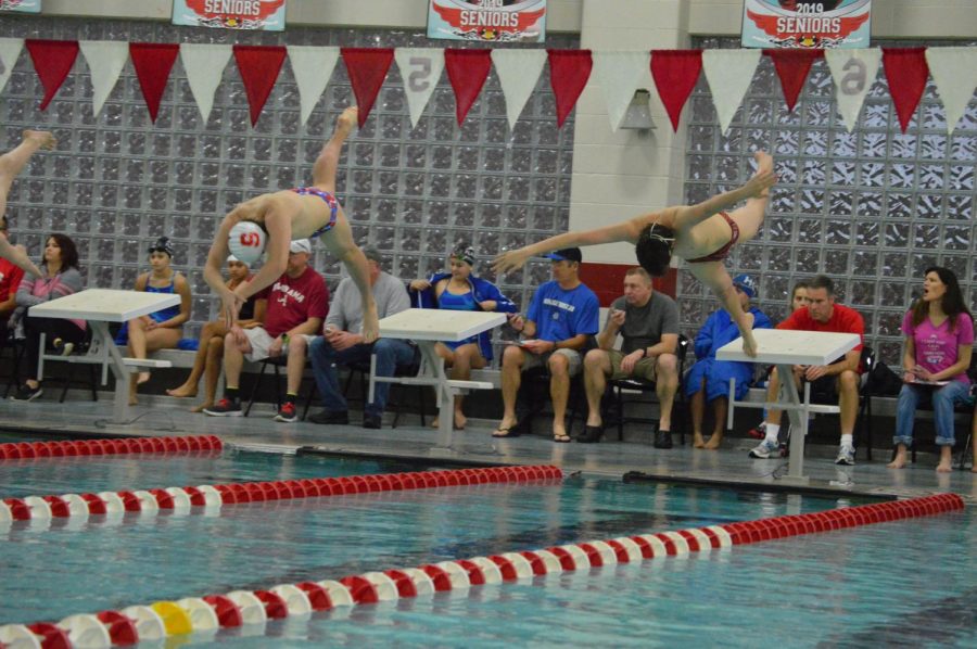Senior+Drew+Reinke+%28left%29dives+into+the+pool+to+start+the+200-yard+freestyle.+He+finished+in+first+place+with+a+time+of+1%3A48.17.+