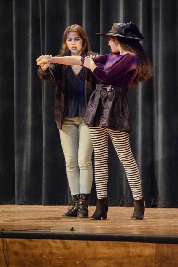 Junior Lilly Leslie checks freshman Talia Sizemores characters arm for evidence that her boyfried is cheating on her in the one act play.