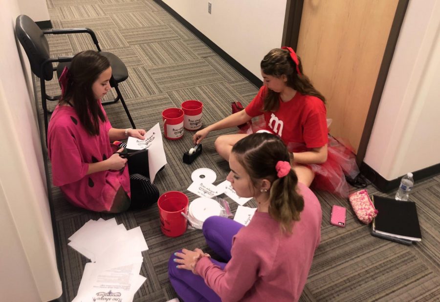 Seniors Alyssa Hightower, Aubrey Popovic and Alyssa Smith work on labeling the No-Shave November buckets for the teachers who took part in the fundraiser in November of 2018.