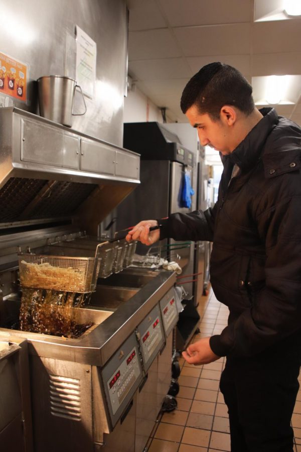 Saeed works on the fryer on Nov. 5. He started working at McDonald’s only three months after fleeing Syria and is now a manager at his store. 