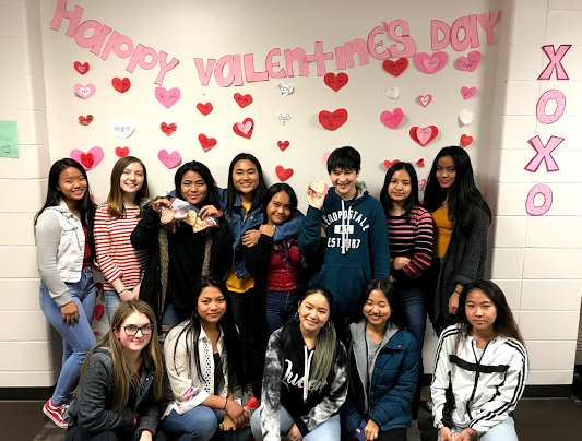 Los miembros del International Club se toman una foto después de decorar el salón de idiomas extranjeros para el Día de San Valentín.
