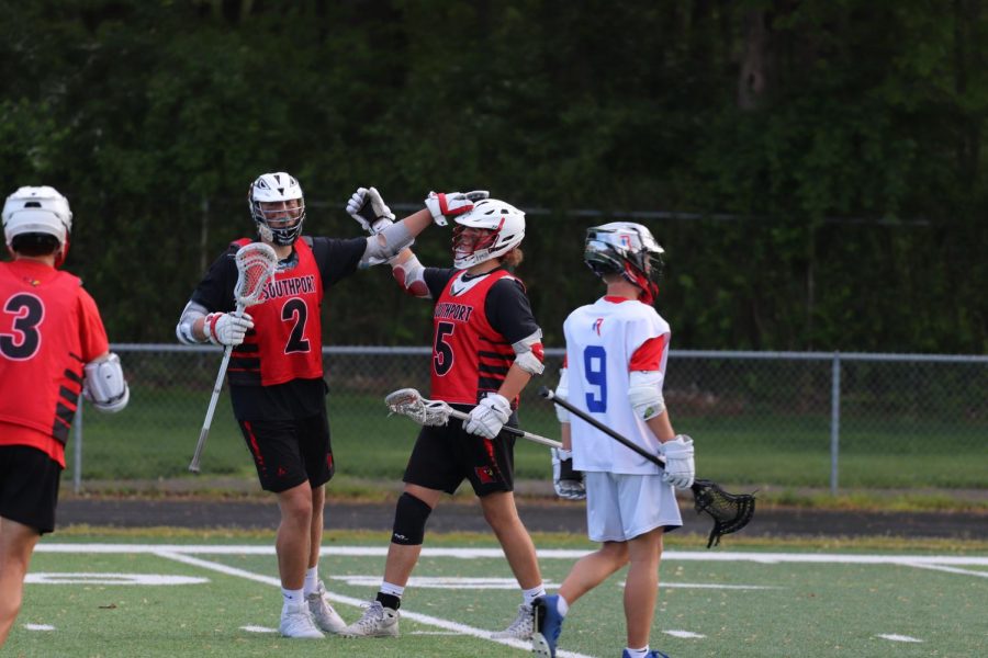 Seniors Griffin Thomas and Tristan Dyson celebrate after Dyson scores a goal. Dyson finished with three goals in the Cards 20-7 win against Roncalli on May 7.