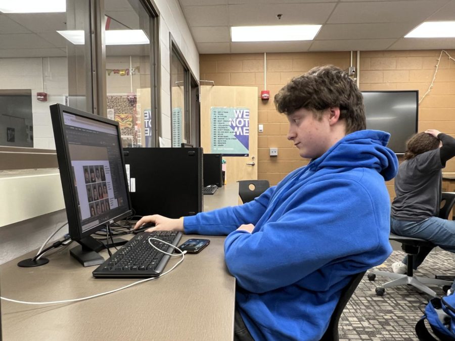 Senior Jackson Ziegler works on the Anchor pages that will hold the scannable photos. Scanning will allow students to view photos of their school year that they have uploaded. Photo by Gretchen Turner