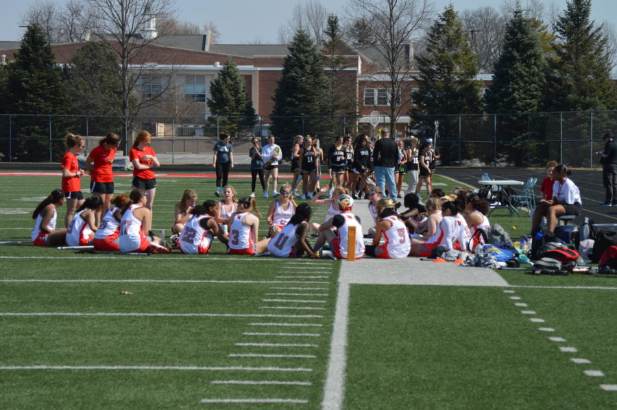 The girls lacrosse team sits in a circle stretching and recapping their first game.                  The Lady Cards lost to Noblesville 7-2 on March 5.