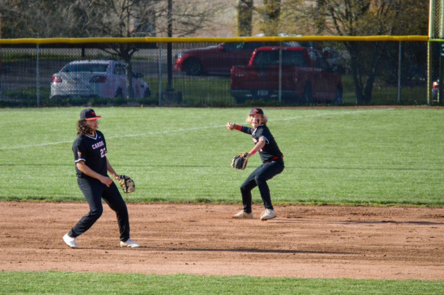 Freshman Nick Godsey throws the ball to first base in order to secure an out on April 21 at Holder Field. The Cards beat New Palestine 4-3.