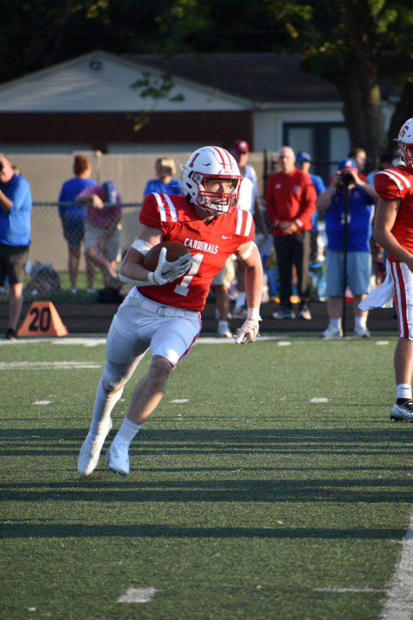 Senior Pierce Birge runs the ball downfield at the teams game vs. Roncalli on Aug. 19. The Cards lost 46-7.