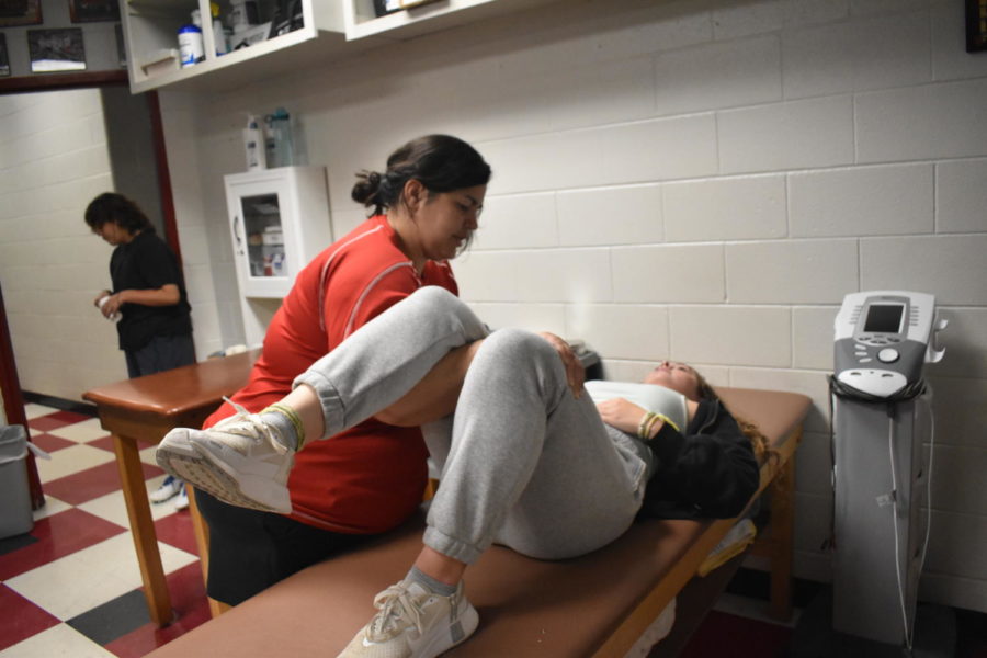 Felicia Cooper preforms manual therapy to put Dorrie Junes hips back into alignment on Aug. 22 in the Athletic Trainers office. This process requires several steps.