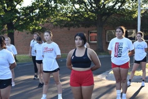 Alex Torres (middle), Lucy Kautsky (second to right) and the rest of the dance team stand at ready position during practice in the parking lot on Aug. 31. The team hasnt had a male member since 2012.