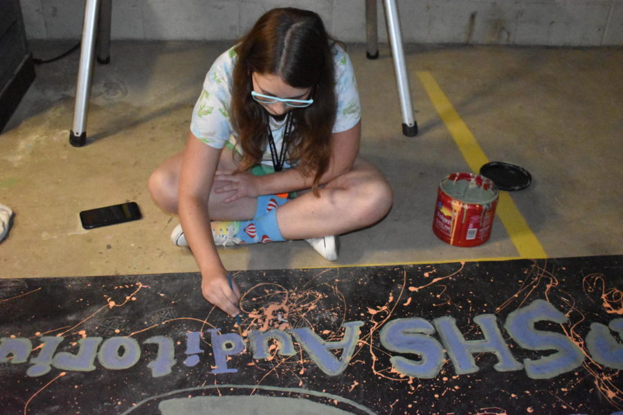 Senior Madelyn Sage paints a sign for the fall musical on Sept. 6. Theatre Production is in the process of creating ways to promote the musical.