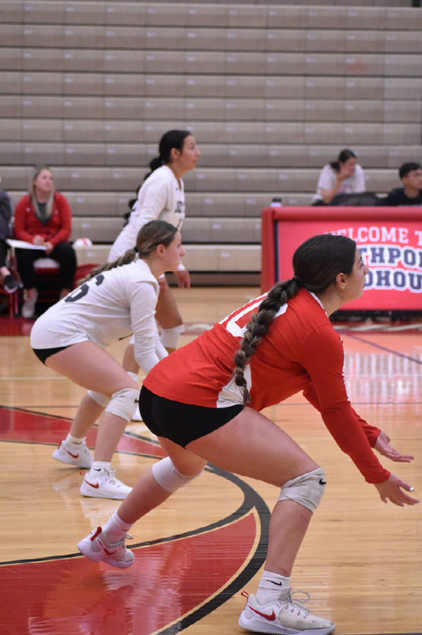 Senior Olivia Acker stands ready for the serve alongside the back row on Sept. 26 at the Southport Fieldhouse. All three players in this photo are seniors on the Cards volleyball team.