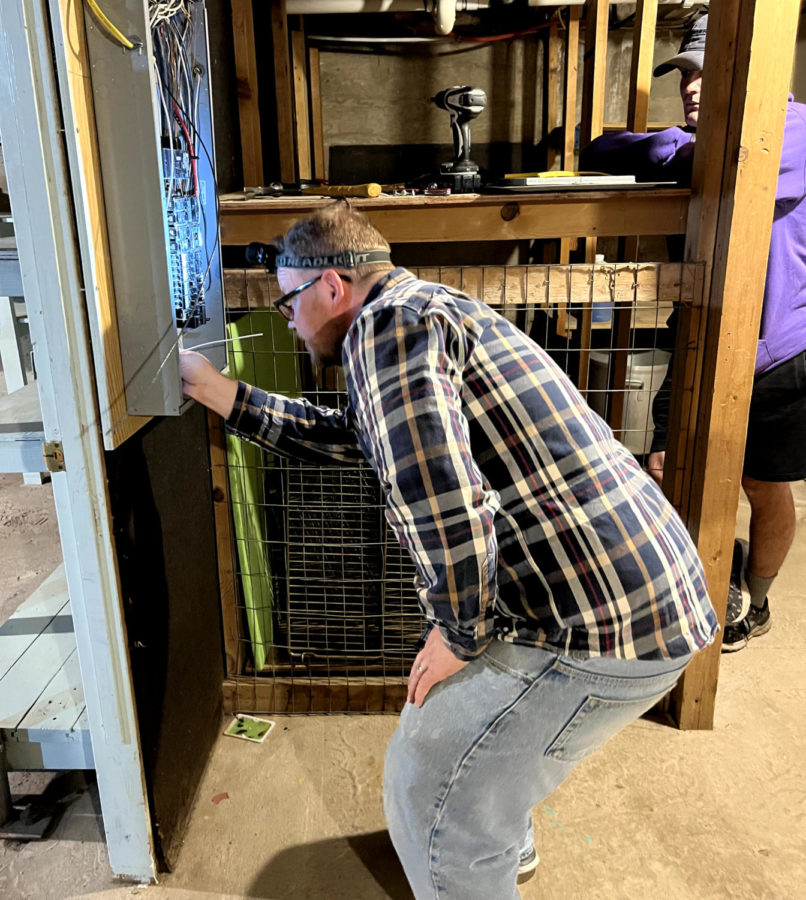 Jack Williams is adds a circuit to a service panel for a new exit sign he installed in the kitchen storage facility in October. It took about an hour.