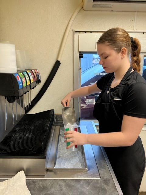 York scoops ice into a cup to fill up a customers drink for a drive-thru order at Enzos Pizza on March 22.
