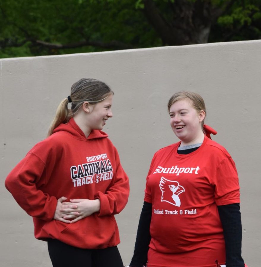 Sisters, junior Mary Pfeiffer (left) and senior Lauren Pfeiffer (right) smile at each other during the long jump of the Unified Track meet on April 25. Participating on the team together has helped the sisters grow closer.
