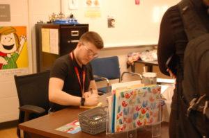 Theater teacher Caleb Francis writes a pass for a student. This was in his Theater Arts 2 class. 