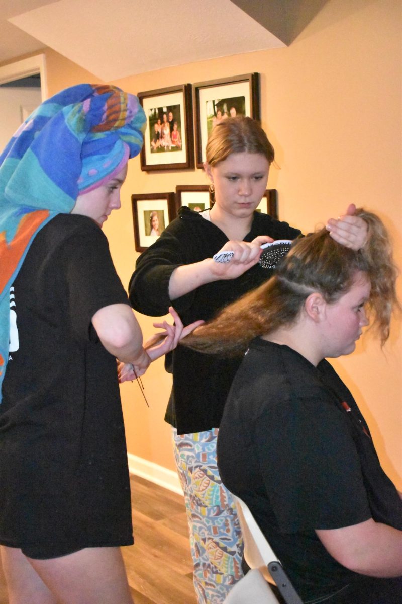 Sophomore Adelynn Davis (left) and sophomore Halle Kenyon (middle) are sectioning out and getting sophomore Faith Johnsons (right) hair ready to dye.