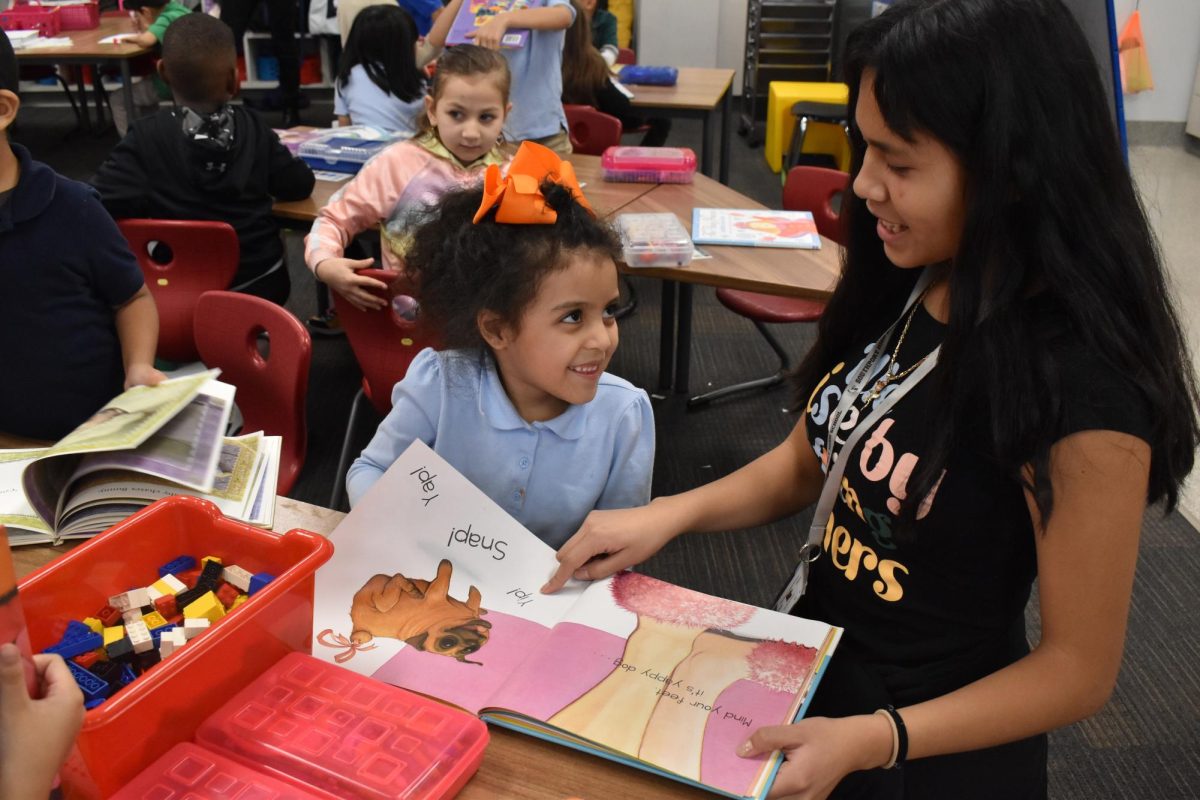 Junior Ashley Martinez reads a book with a kindergartner on Thursday, Feb. 2. 