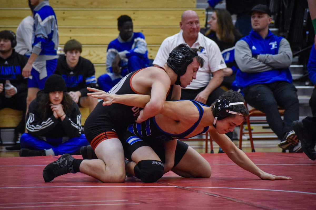 Senior Brayden McMillan puts his opponent’s hands behind his back in an attempt to pin him.