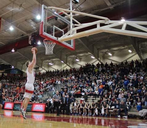Former student Joey Brunk dunks the ball during the game against Evansville Reitz on Feb. 28, 2015. The Cards won the game 88-80.