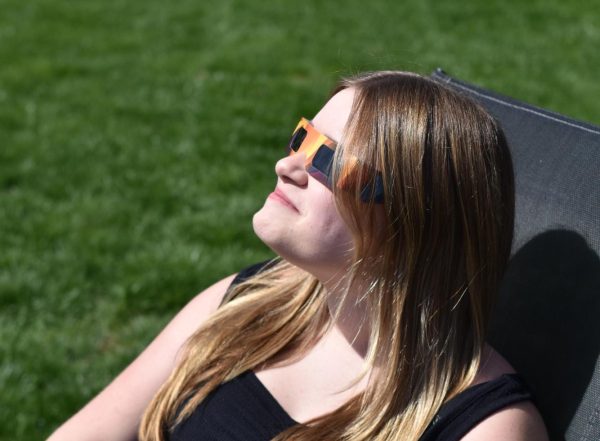 Freshman Piper Leber observes the eclipse through her protective glasses on April 8. Over 75 million eclipse glasses were manufactured. in the U.S. for this single event.