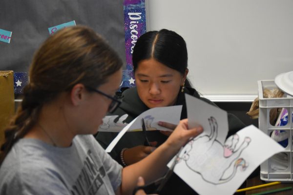 Sophomores Amelia Pennington and Tiffany Quach cut out cows during the International Club meeting on Tuesday, Sep.17. Students learned about Germany.