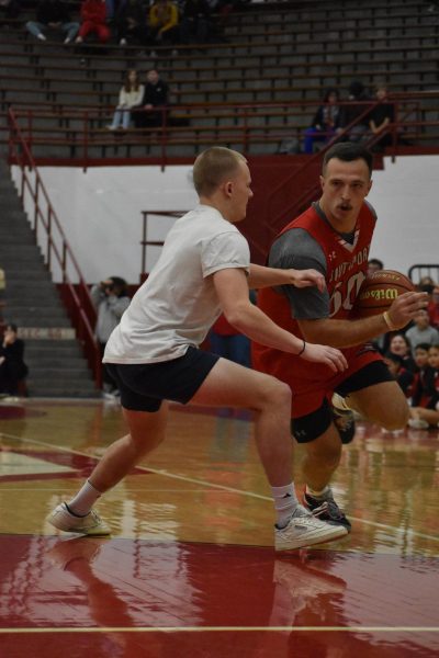 Alumus Noah Daniel guards business teacher Brendan Dudas at the winter pep rally last year. This is the last year that the basketball game will be played.