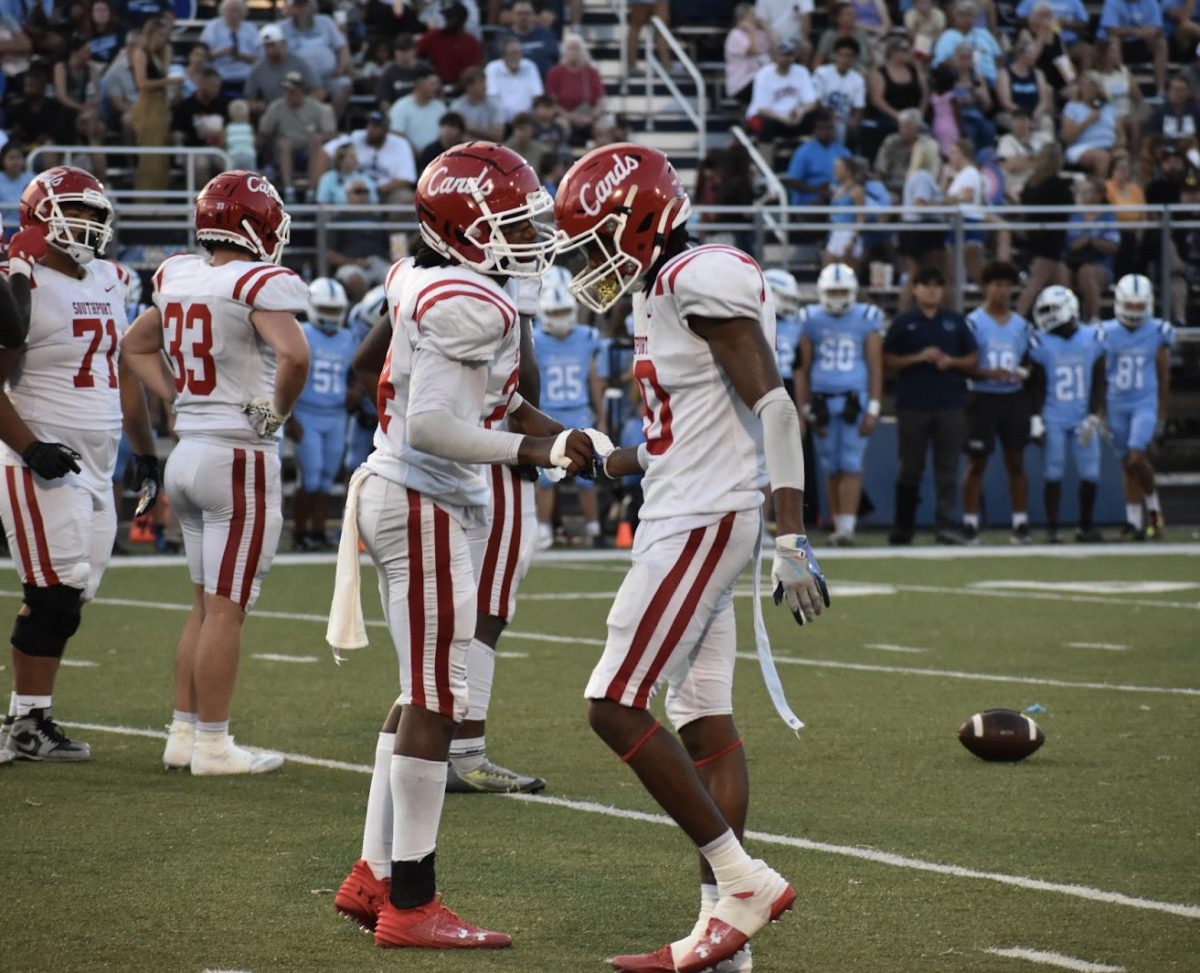 Senior Malachai Kennedy and junior Jeremiah Stanovic meet up to talk in between plays during the away game at Perry Meridian on Aug. 30. (photo by Aiden Quinlin)