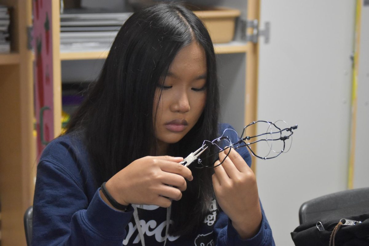 Junior Zerami Cung crafts together a project with soda can parts on Thursday, Sept. 26 in the Sculpture class, inspired by South Africa.