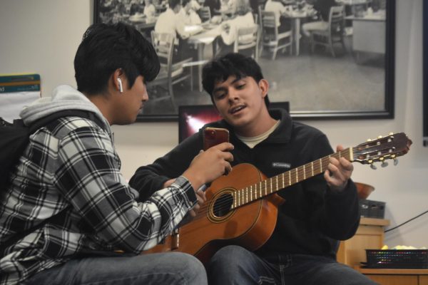 Senior Gabriel Ramirez plays the guitar and sings with the help of senior Cristian Rojas.