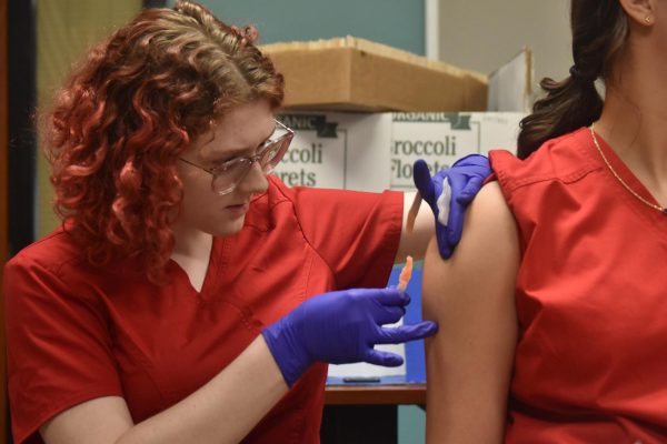 Junior Salem Ehler demonstrates drawing blood from another classmate at C9 on Thursday, Oct. 24. Ehler hopes to study medicine later in life.  photo by Michelle Ortega-Morales