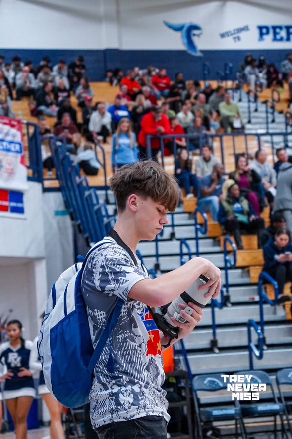 Senior Landon Rossi checks his lense after shooting photos at a game. Rossi began shooting as a hobby after being inspired by someone else. (photo contributed by Landon Rossi.)