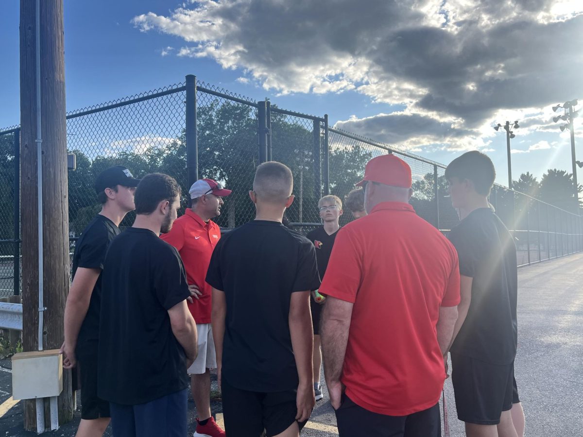 SHS tennis team gathers in a huddle after a 4-1 loss against Franklin Central on Wednesday, Aug. 27. Head coach Isaul Martinez shares his thoughts regarding how the night played out.