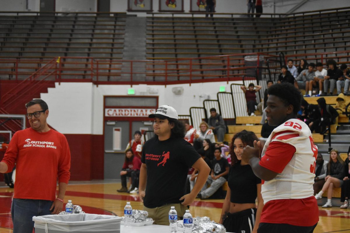 Band director Jeff Maupin, math teacher Justin Magbanua, senior Arilynn Hutcherson and junior D'Anthony Moore wait for the hot dog competition to begin. The hot dog eating contest was the first ever at a SHS pep rally.
