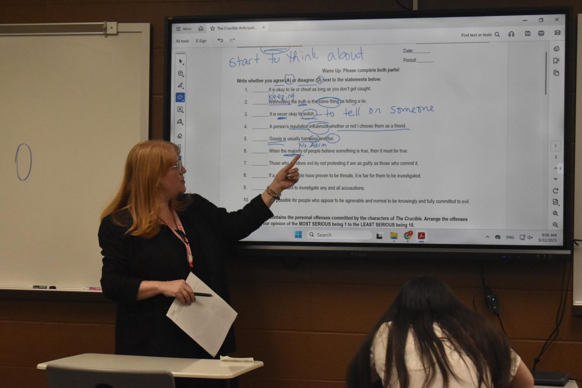 English teacher Dr. Ibouhouten works on a guided worksheet in front of her class. She recieved her doctoral degree from North Central University in 2018. 