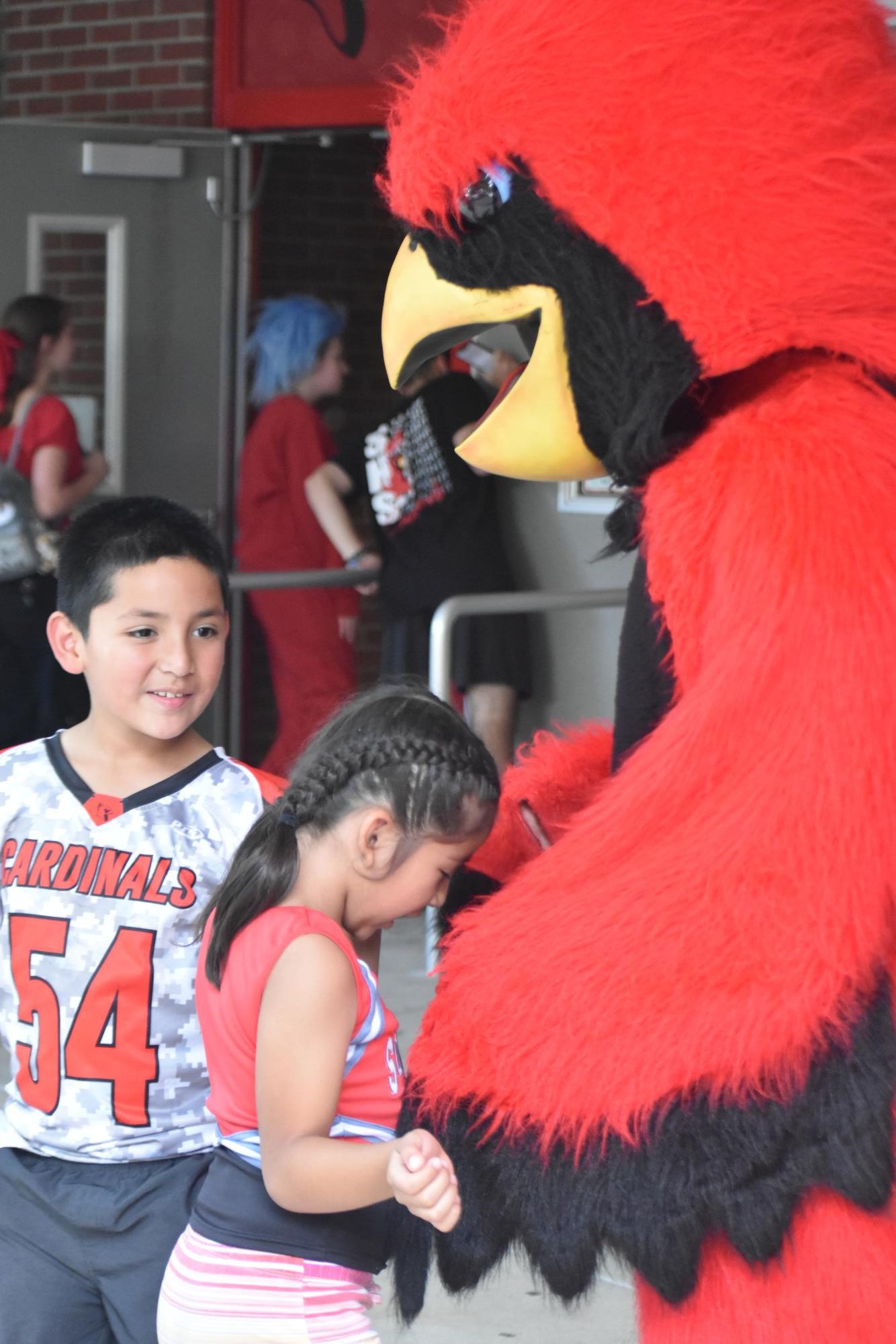 The Cardinal interacts and hugs with the little kids. Beforehand, a swarm of kids approached the Cardinal before the Homecoming Court was announced.