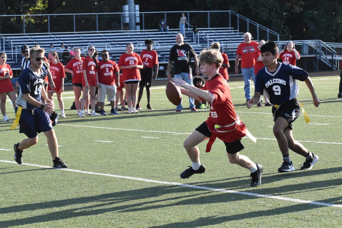 Junior Josiah Bryant runs the ball between Perry defenders. Bryant was stopped which resulted in a third down. 